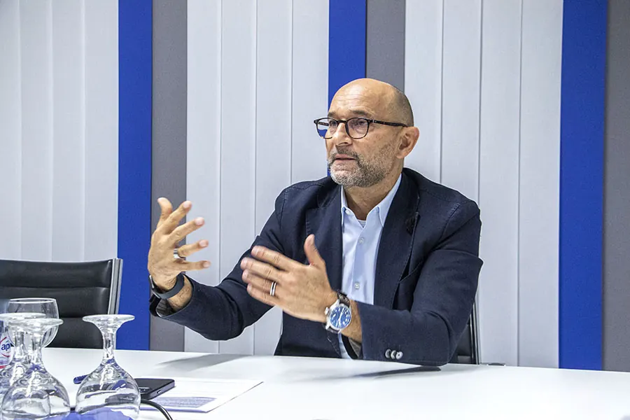 Enzo Santarsiero erläutert im Gespräch am Besprechungstisch etwas mit beiden Händen