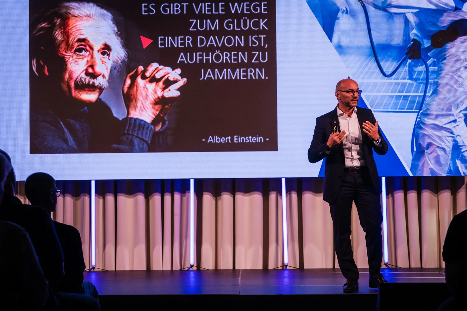 Enzo Santarsiero spricht vor einer Leinwand mit einem Zitat von Albert Einstein