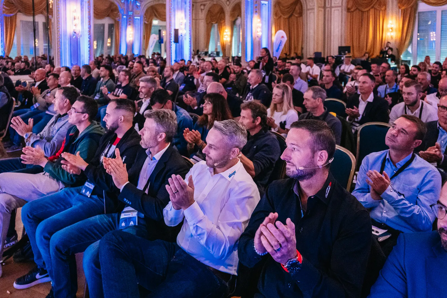 Voll besetzter Saal mit Kronleuchtern, das Publikum applaudiert